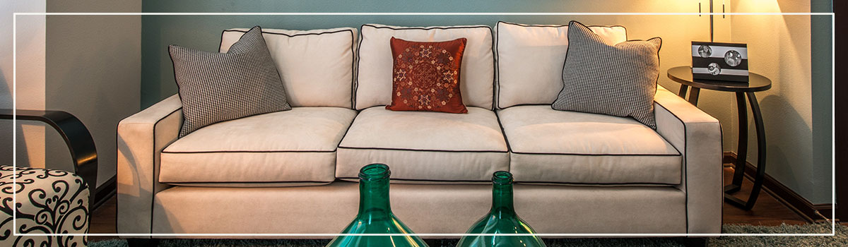 Living room area with couch and pillows, chair seating, and decor