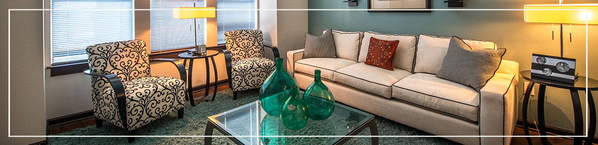 Living room area with couch and pillows, chair seating, and decor